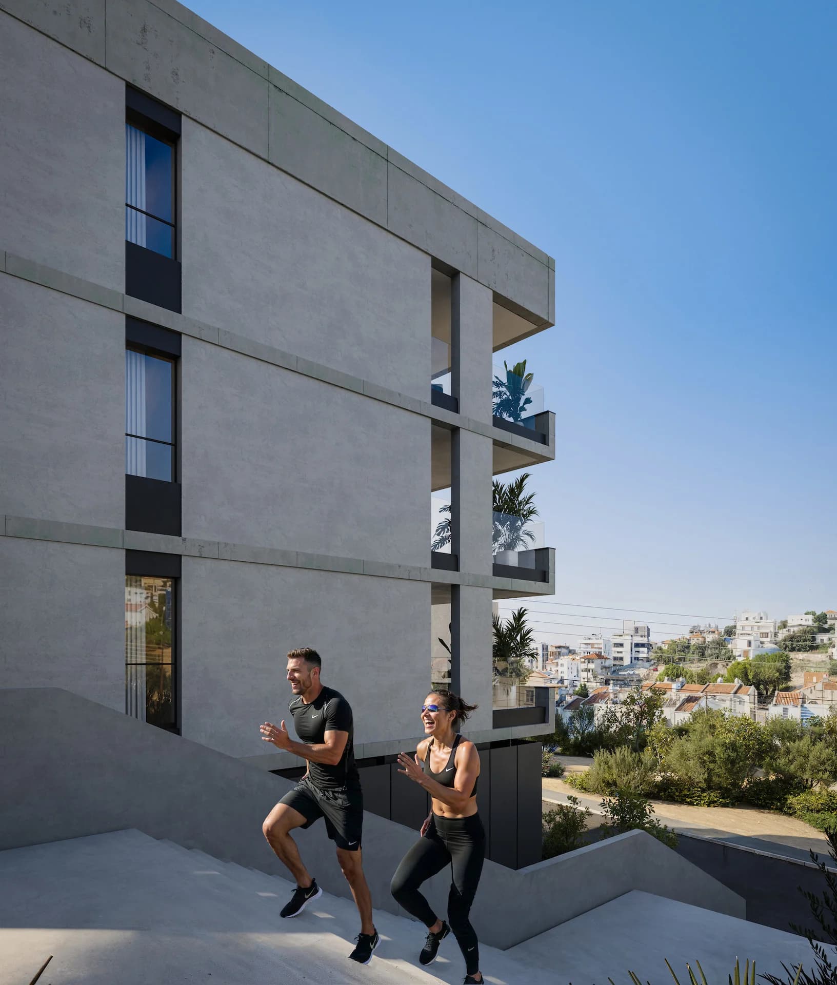 Joggers passing ALDO's pale concrete facade