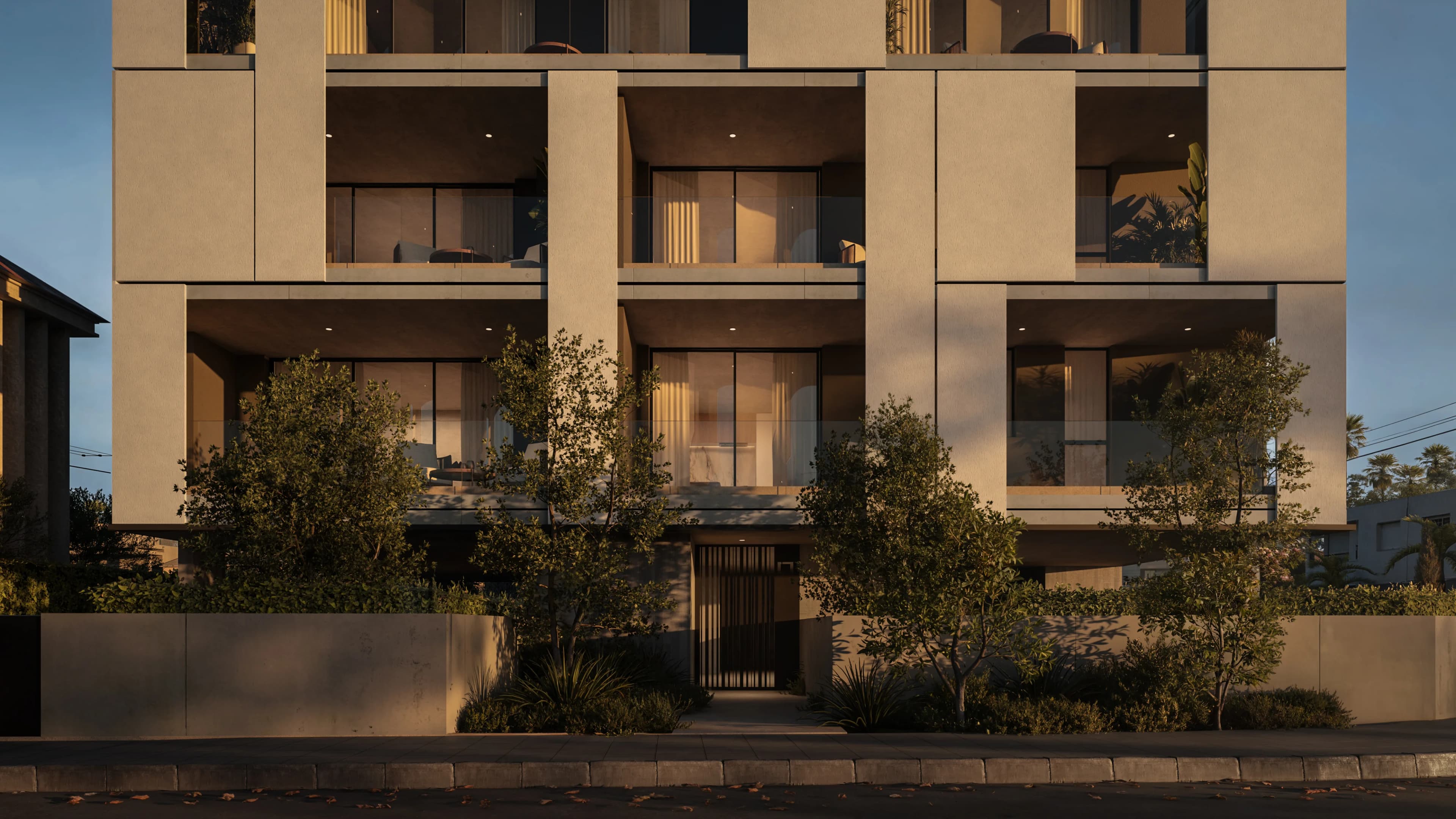 KAIA's warm stone facade at dusk above a planted front garden