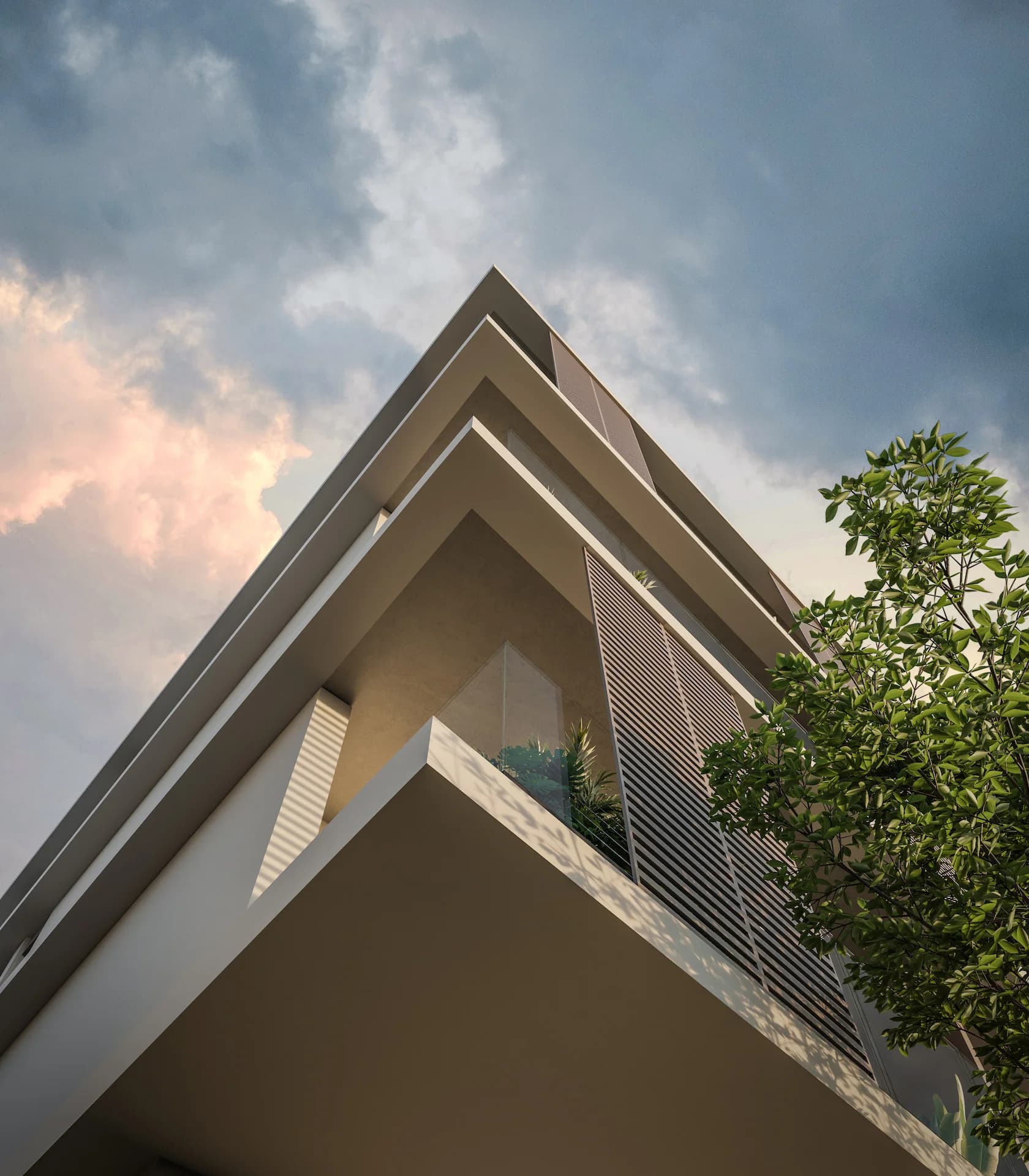 Looking up at NOA's angled balconies against a pink evening sky