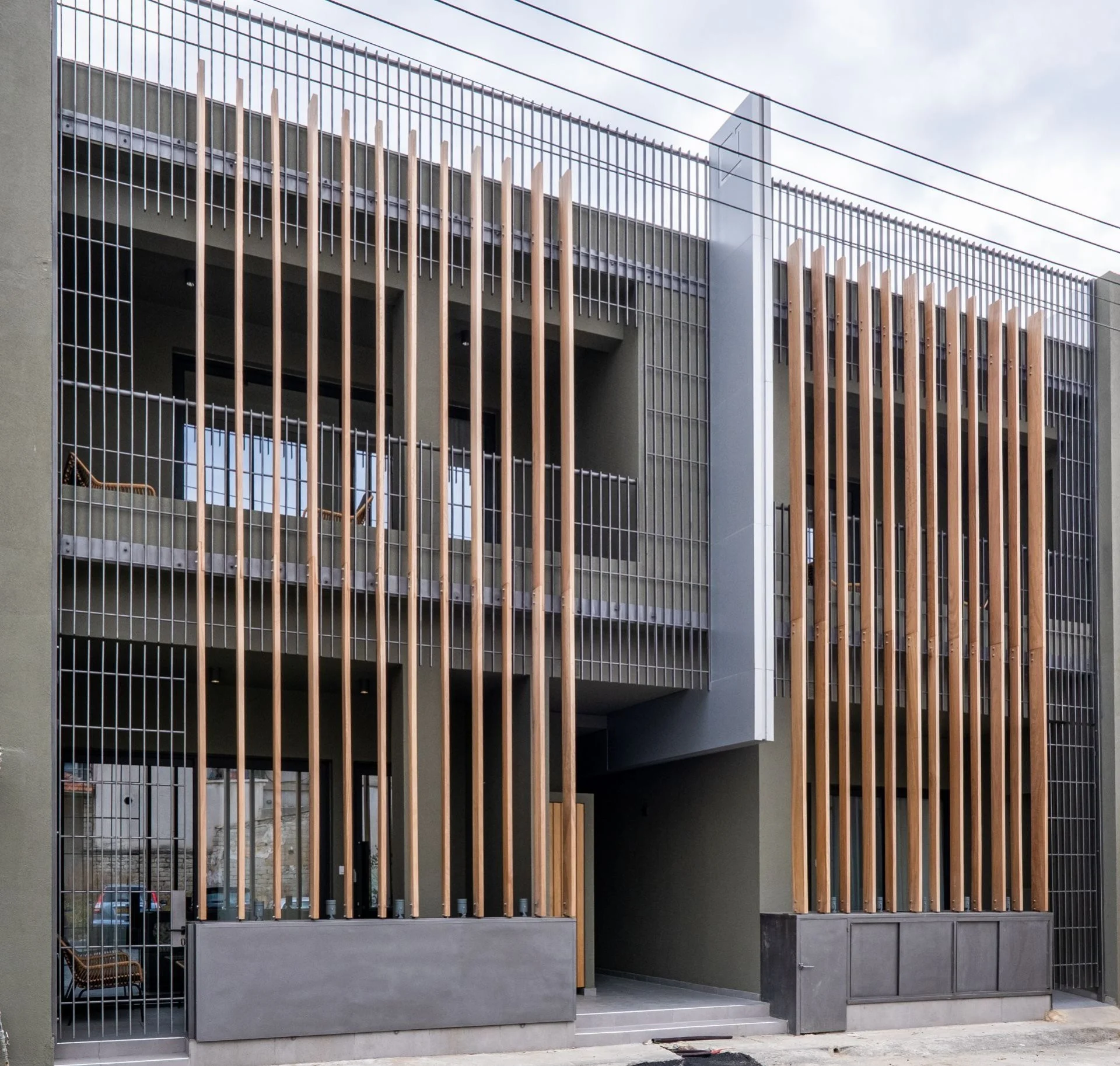 OLYMPIA's facade of timber fins and dark metal balconies