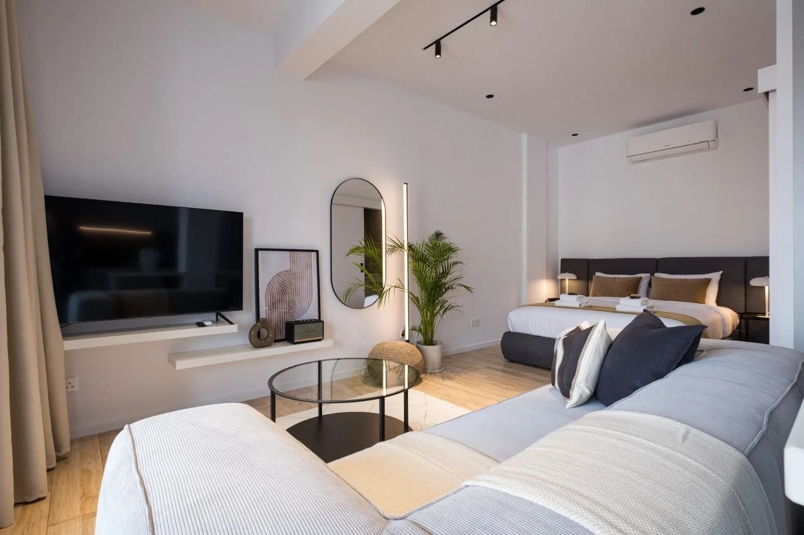 OLYMPIA studio with a bed, sofa and wall-mounted TV