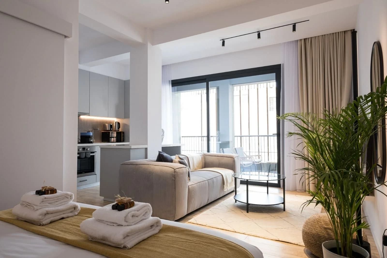 OLYMPIA studio living area with a sofa and a balcony beyond