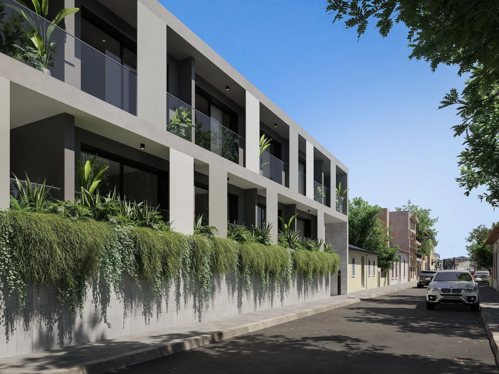 STAY3's balconies above a planted wall along the street