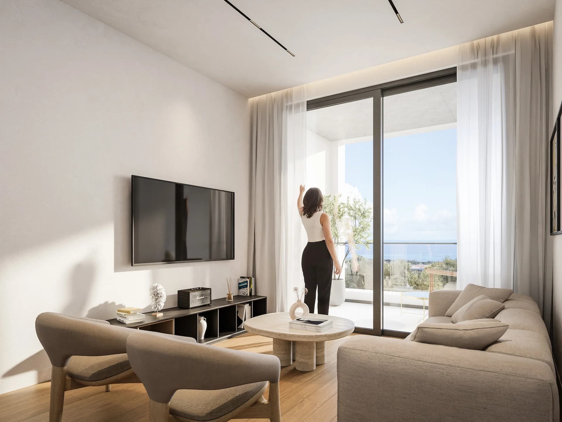 THE COLLECTION living room, a resident opening the curtains onto a sea-view balcony