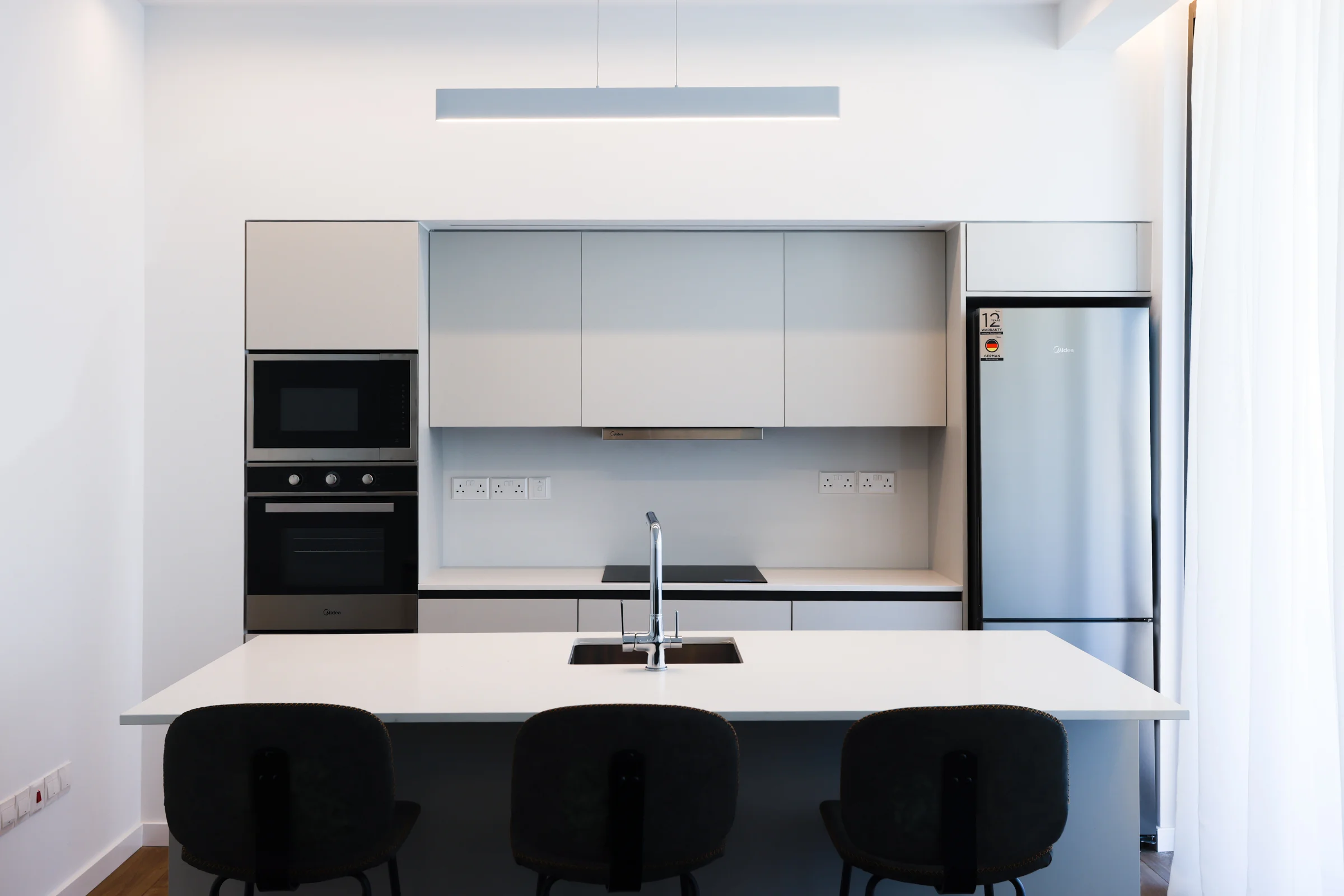 UKIYO kitchen with a white island and built-in appliances