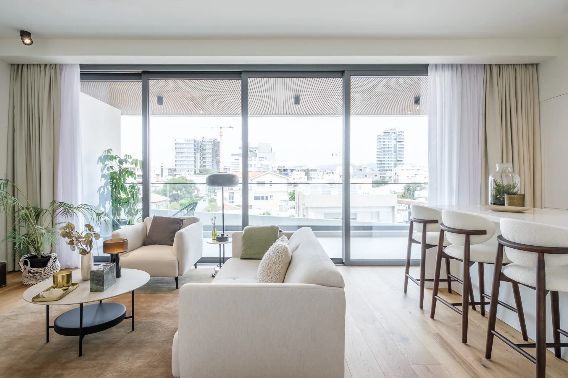URBN living area with floor-to-ceiling glass and city views