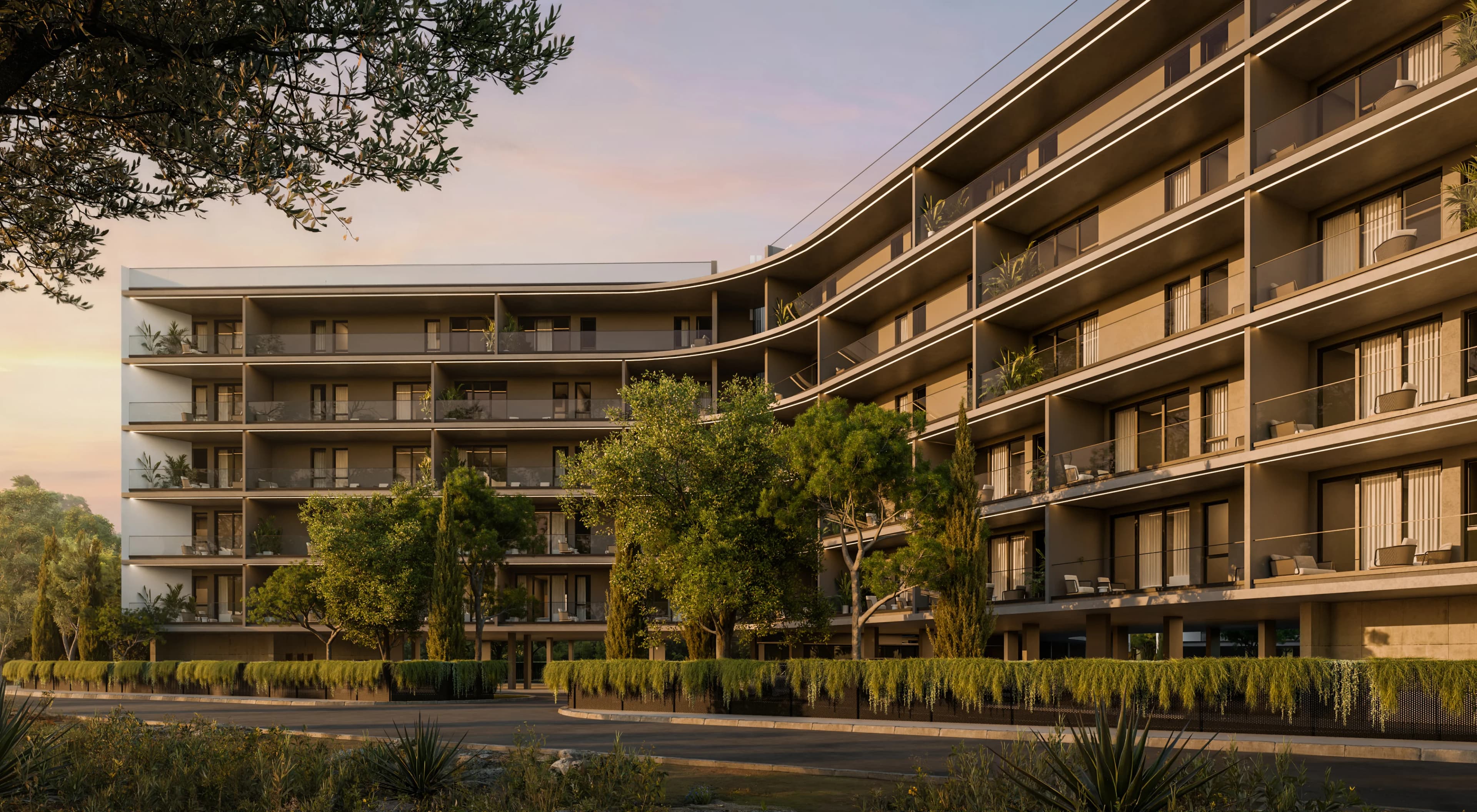 ZOIA's curved five-storey block at sunset, deep balconies lit along their edges behind a row of trees